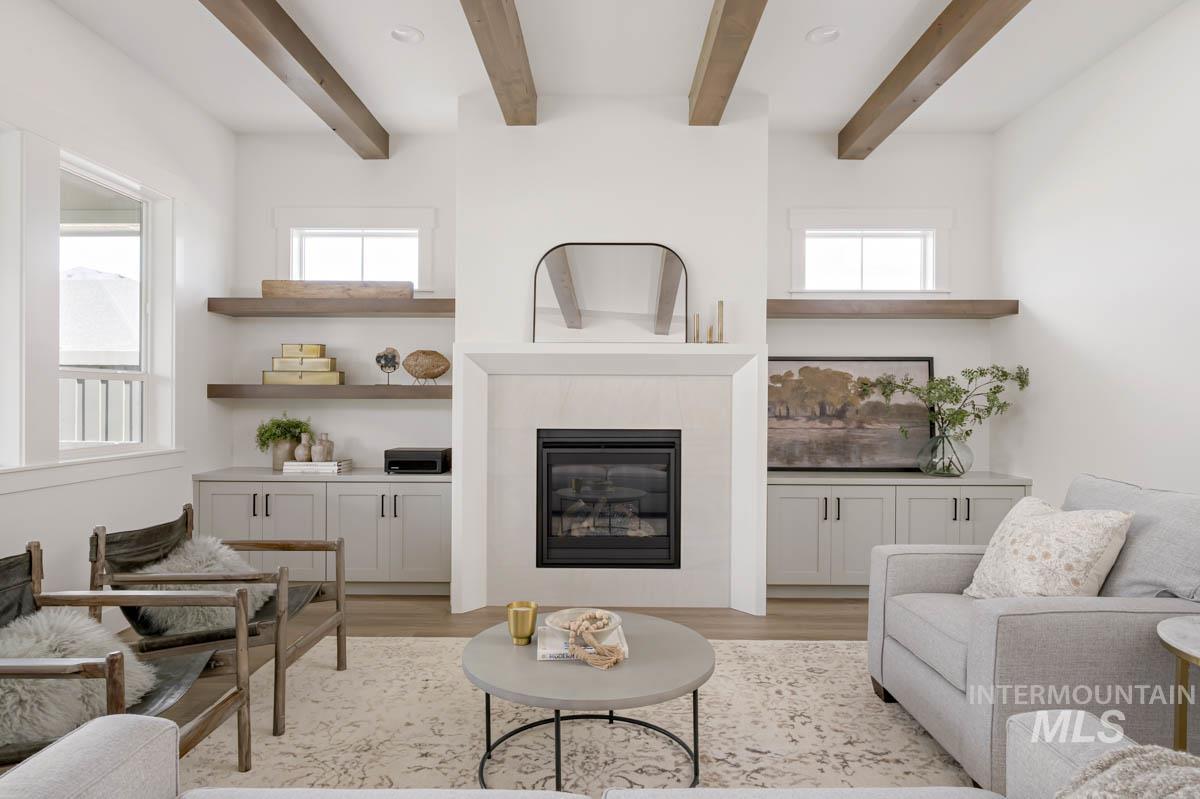 Living room featuring a fireplace, light wood-type flooring, and beam ceiling