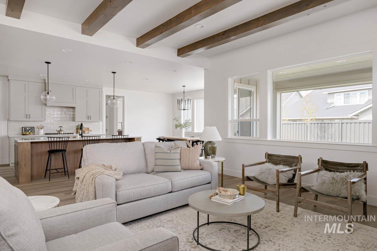 Living area featuring healthy amount of natural light, light wood-type flooring, beam ceiling, and recessed lighting