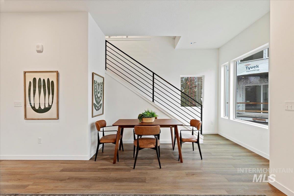Dining area featuring light wood-style floors and stairway