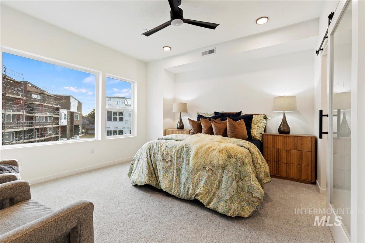 Bedroom featuring a barn door, carpet, a ceiling fan, and recessed lighting
