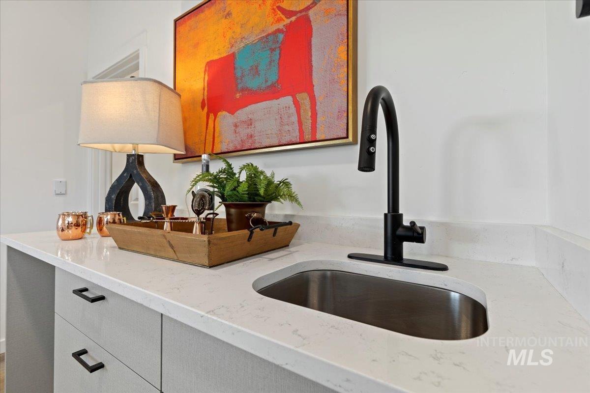 Kitchen featuring light stone countertops and a sink