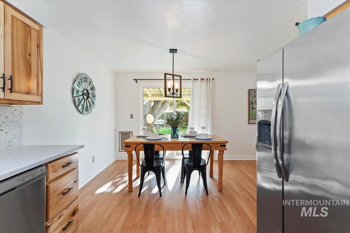 Dining area with light wood-style floors and a chandelier