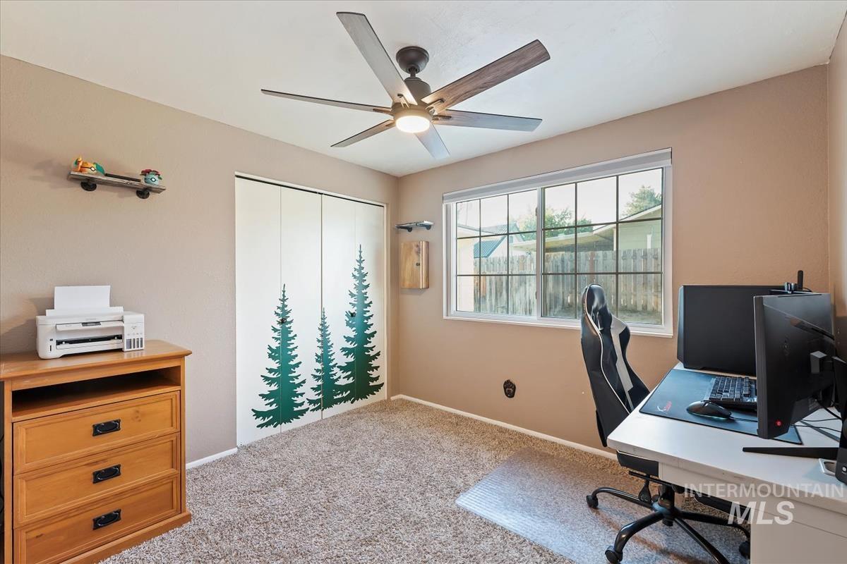 Office with light colored carpet and ceiling fan