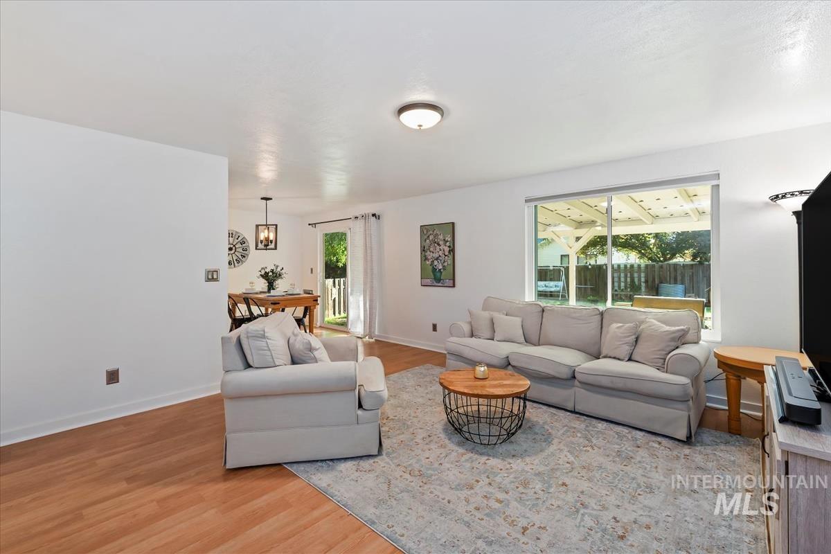 Living room with light wood finished floors and healthy amount of natural light