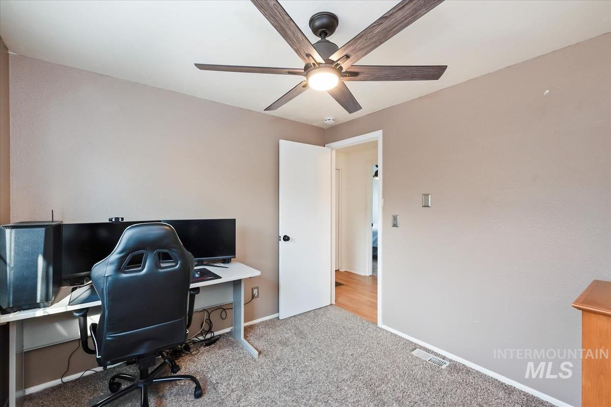 Office area featuring carpet floors and ceiling fan
