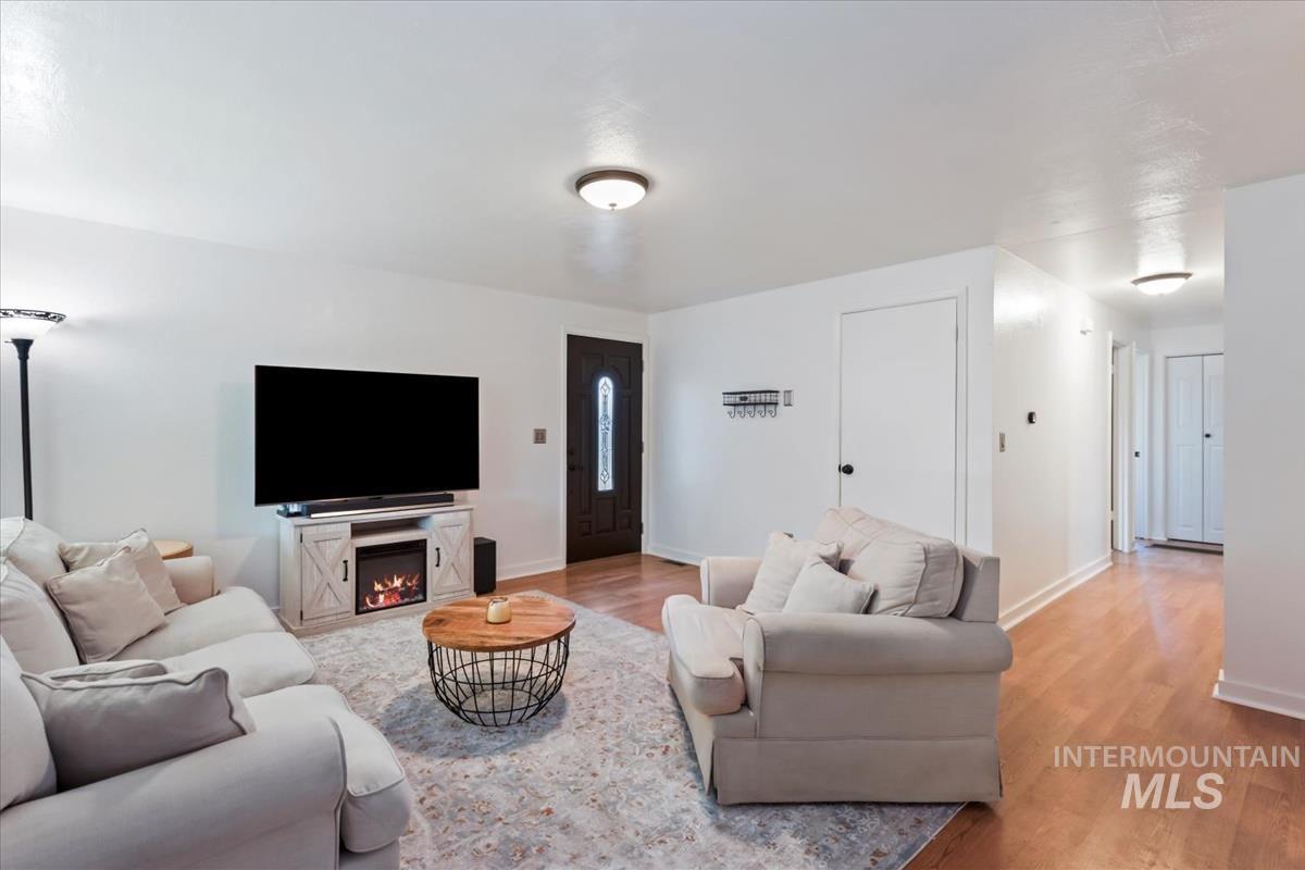 Living room featuring light wood finished floors and a lit fireplace