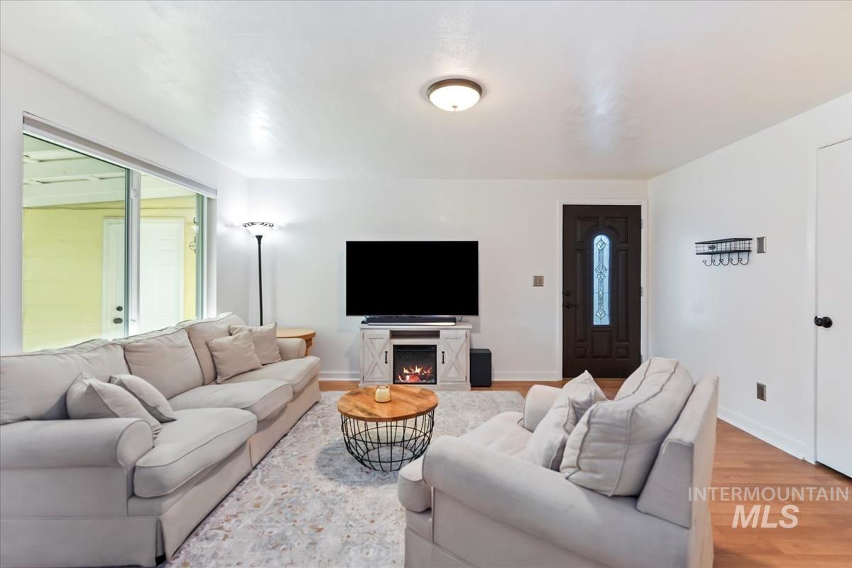 Living area featuring wood finished floors, plenty of natural light, and a lit fireplace