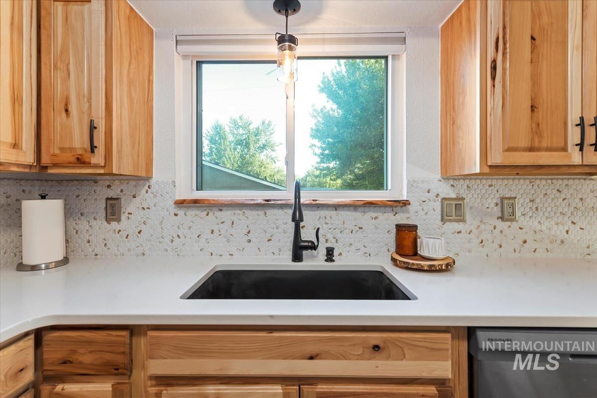 Kitchen with tasteful backsplash and dishwasher
