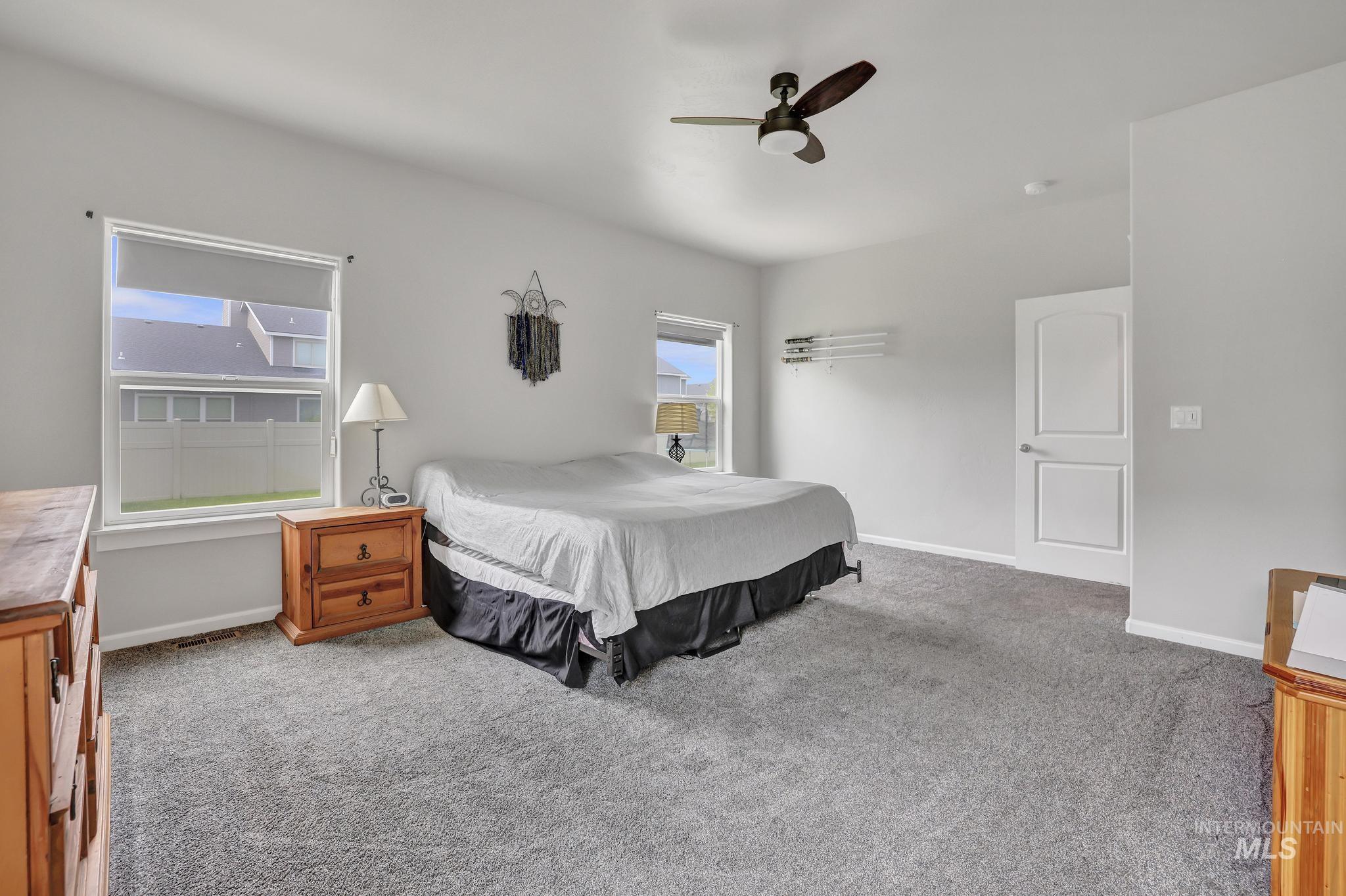 Carpeted bedroom with baseboards and ceiling fan