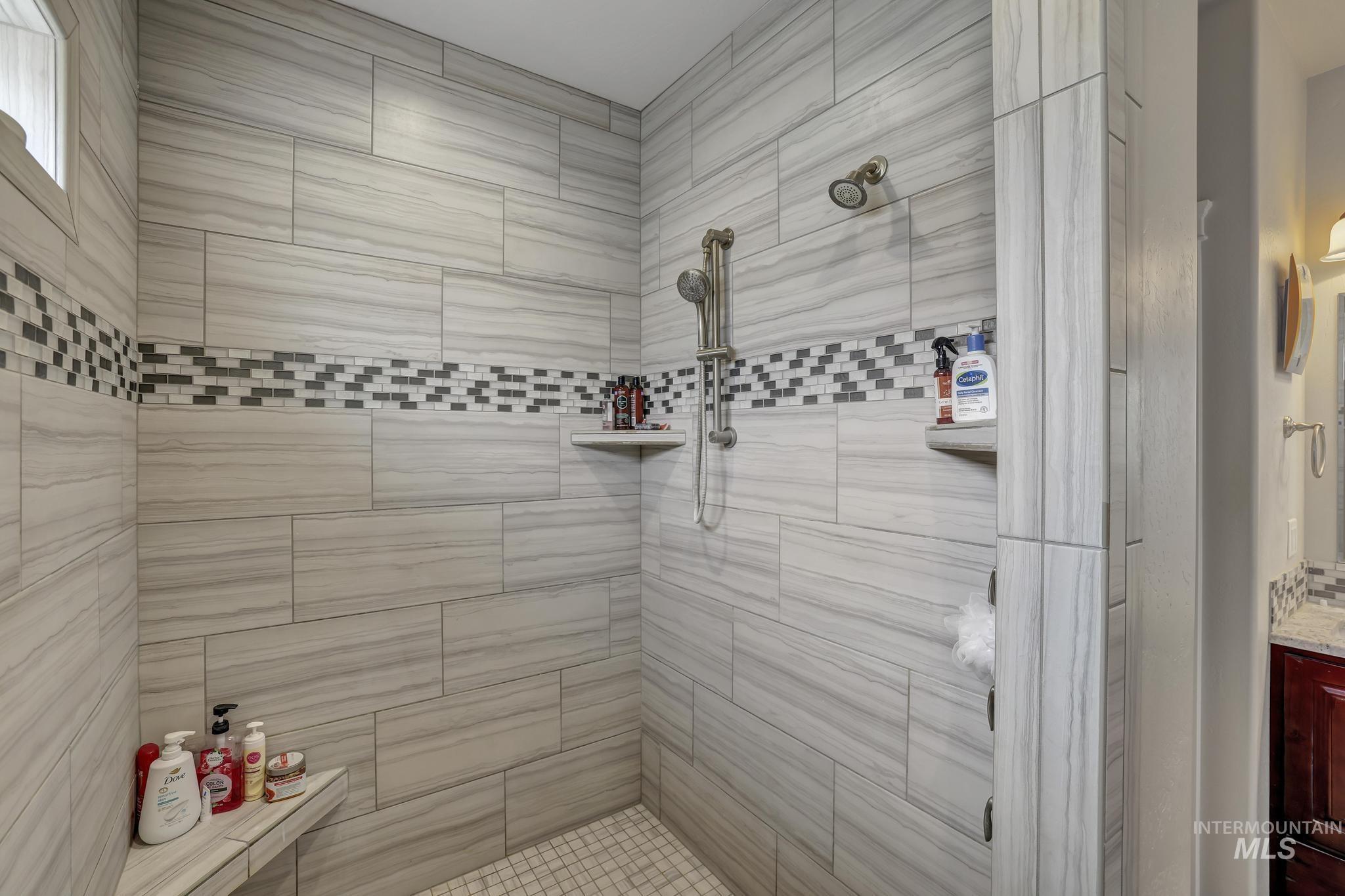 Full bathroom featuring a tile shower and vanity