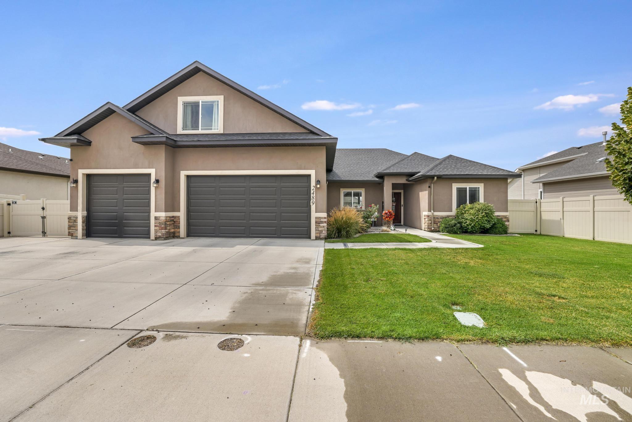 View of front of house with stone siding, stucco siding, concrete driveway, and an attached garage
