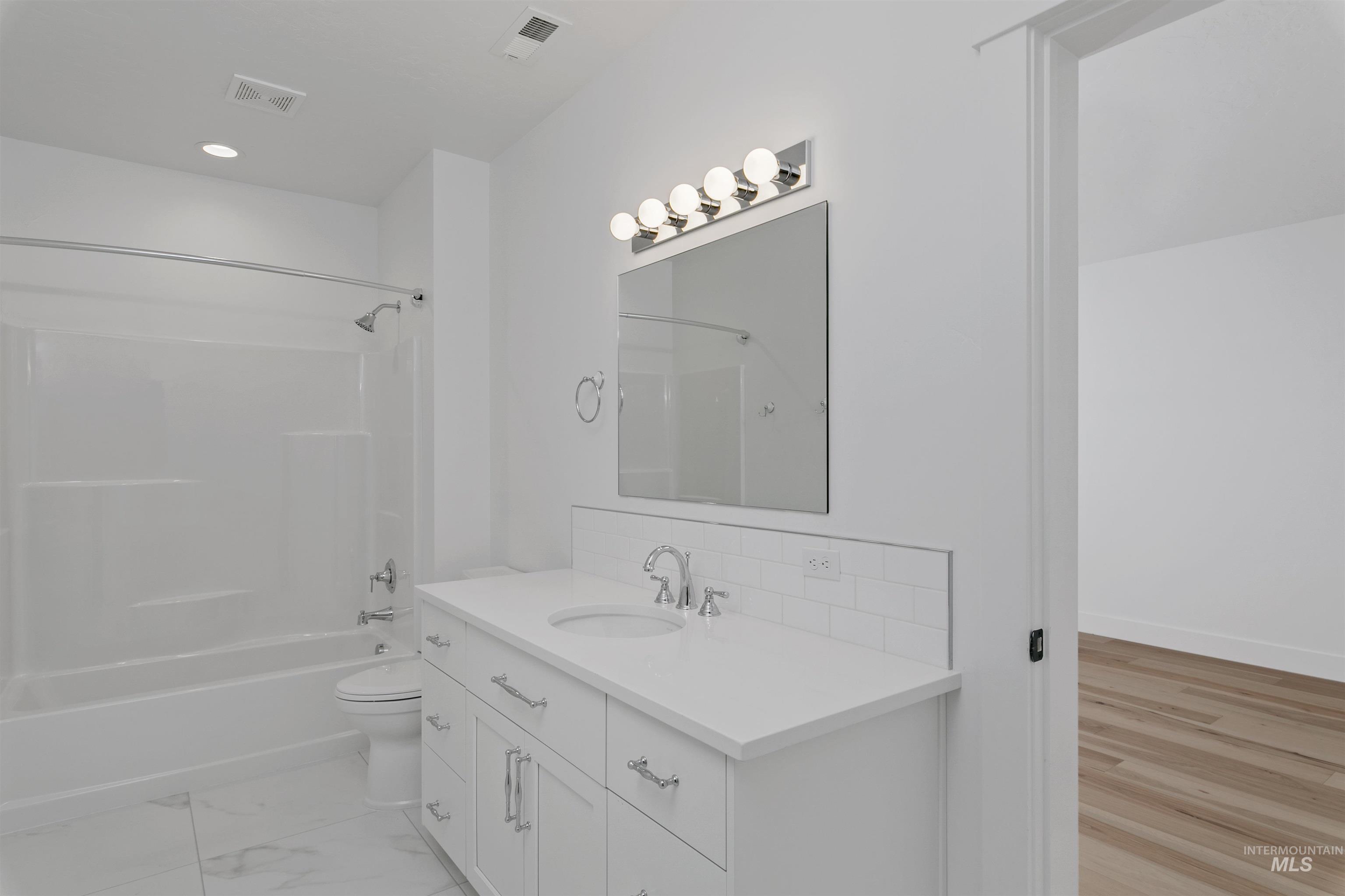 Bathroom with shower / bathtub combination, vanity, and recessed lighting