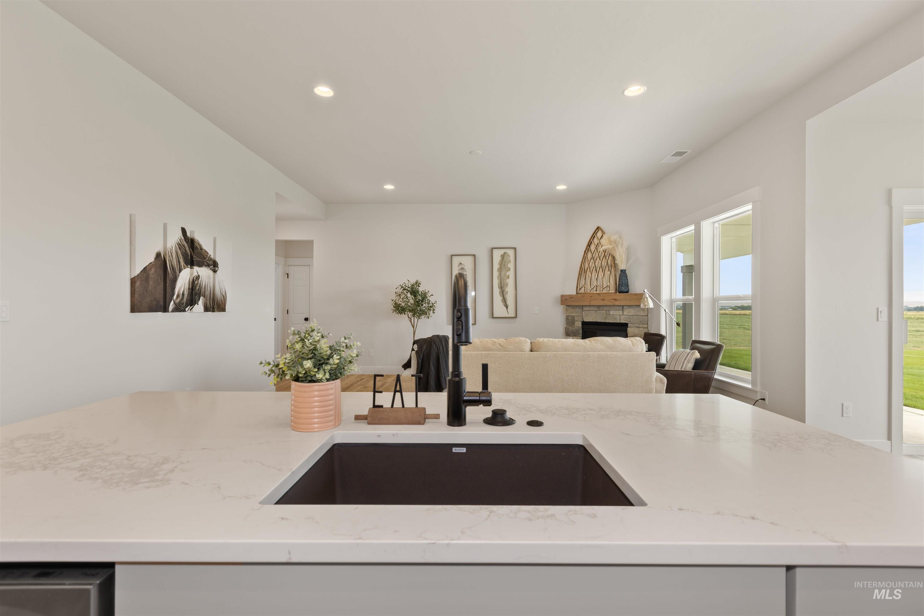 Kitchen with light stone counters, recessed lighting, a fireplace, and open floor plan