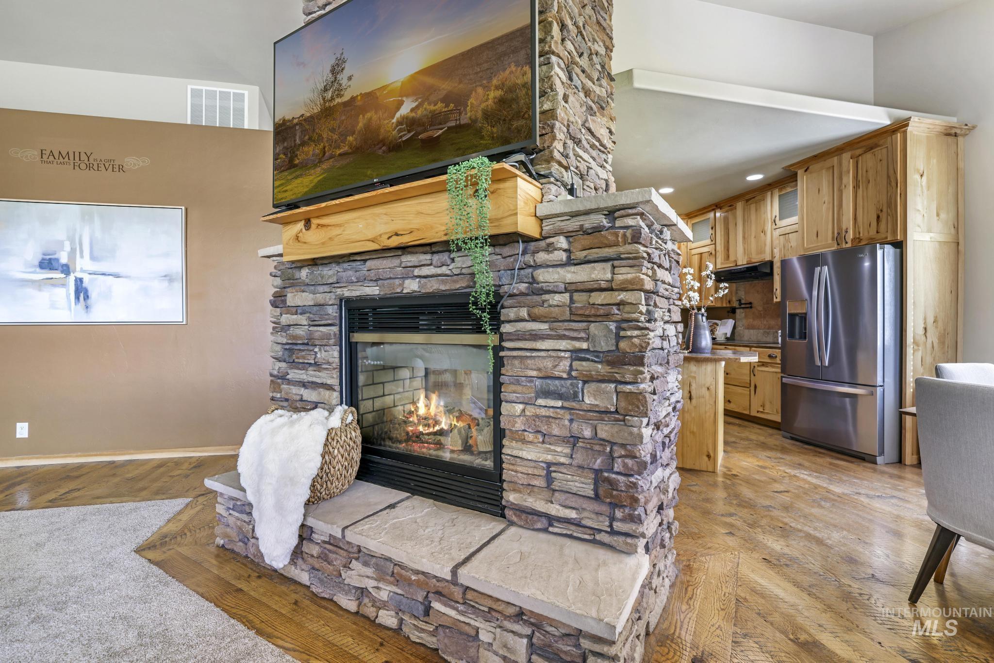 Living area featuring a stone fireplace and light wood-type flooring
