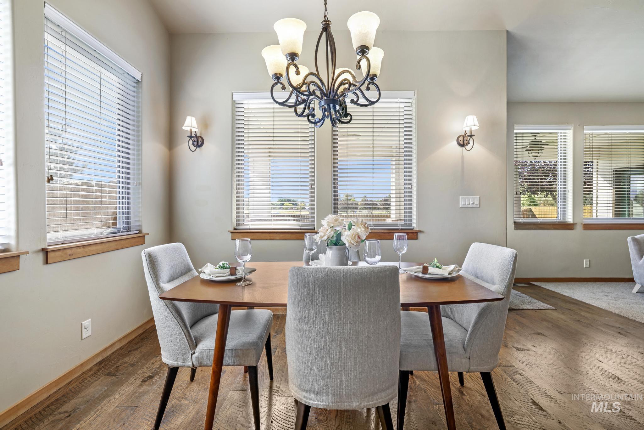 Dining area featuring dark wood-style flooring and a chandelier