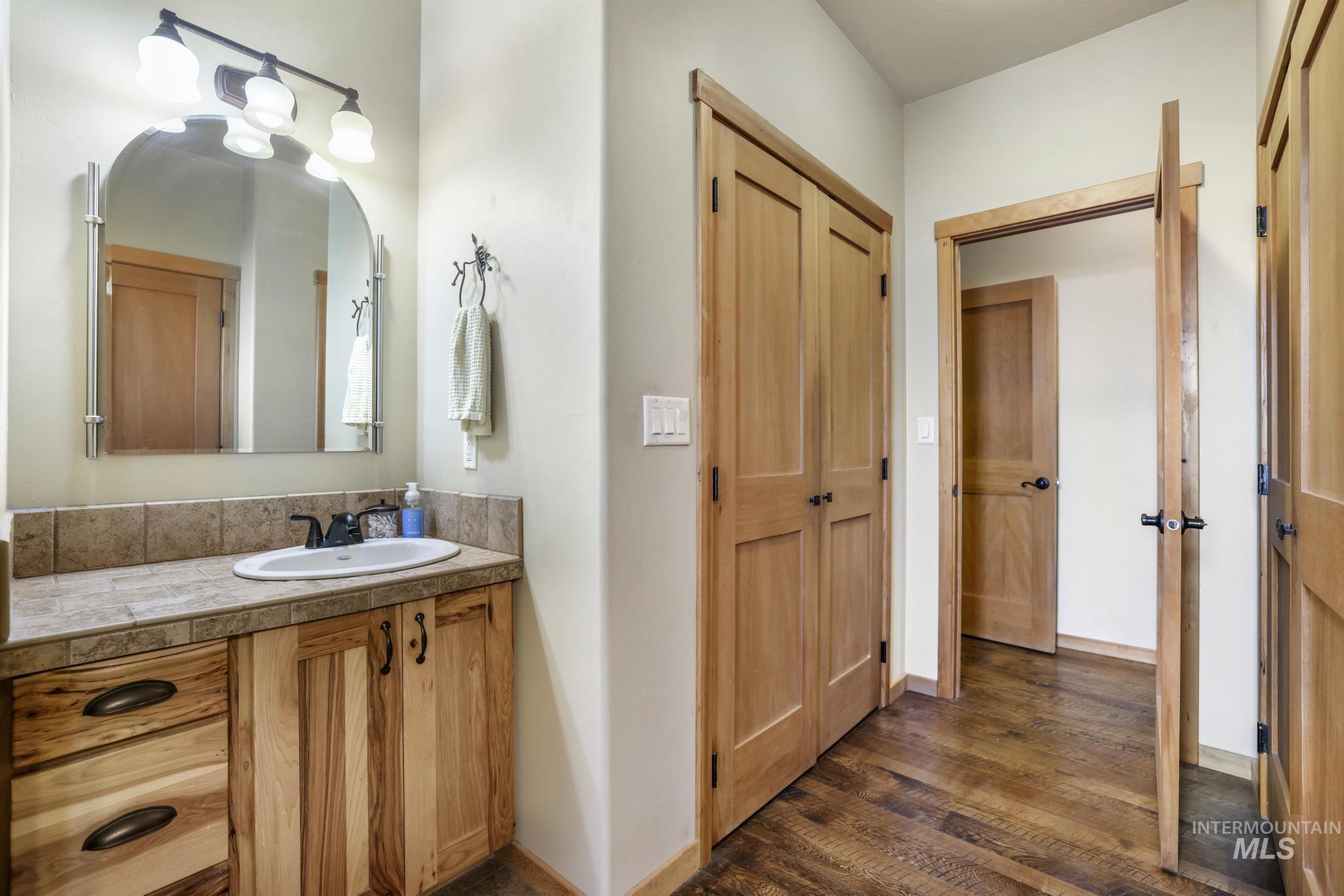Bathroom featuring vanity and dark wood-style flooring