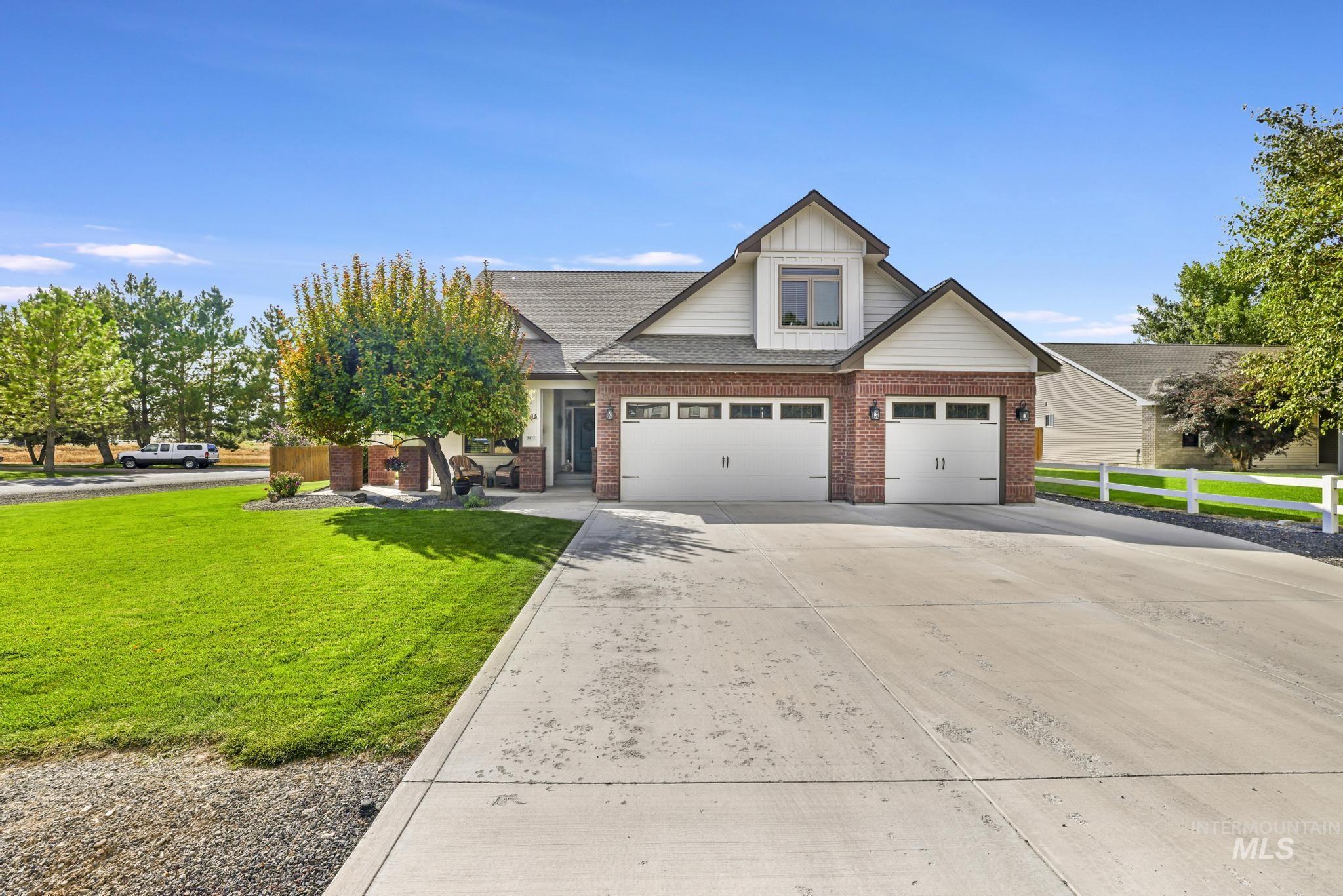 Craftsman-style home with driveway, board and batten siding, brick siding, a garage, and a shingled roof