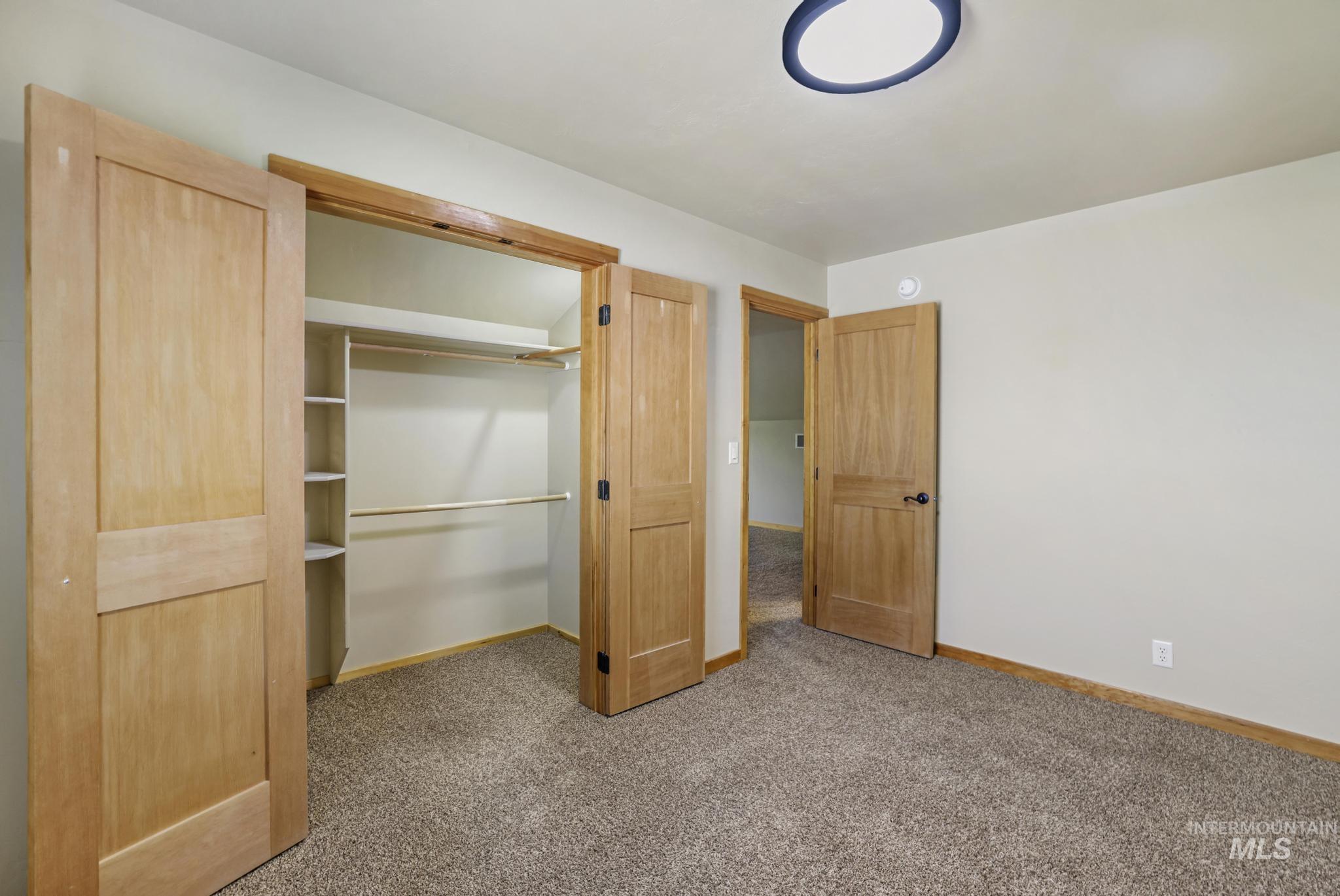 Unfurnished bedroom featuring light carpet and a closet