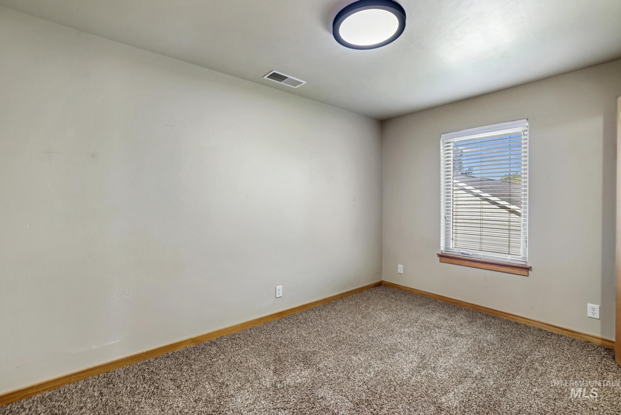 Carpeted spare room with baseboards