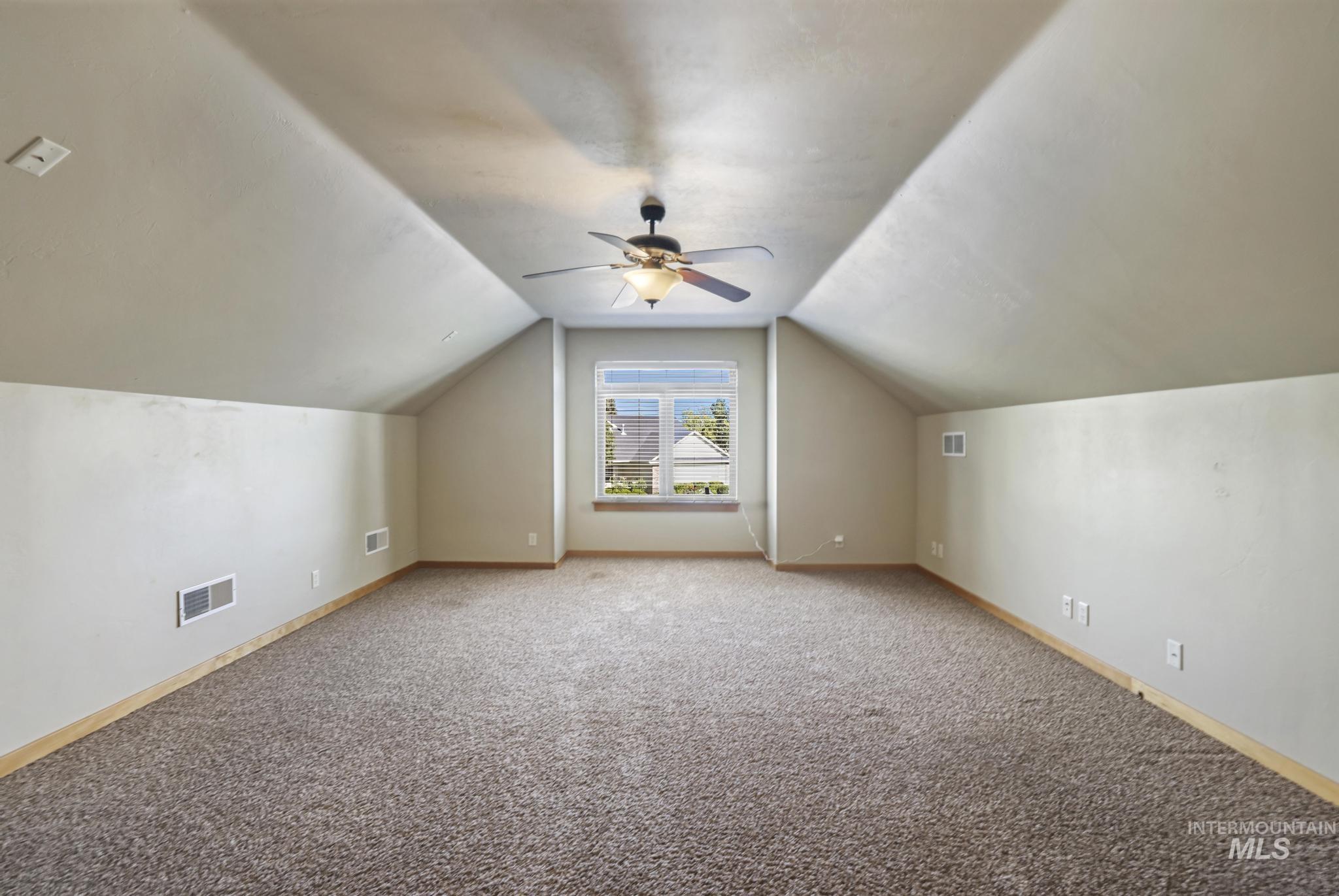 Bonus room featuring carpet floors, lofted ceiling, and ceiling fan