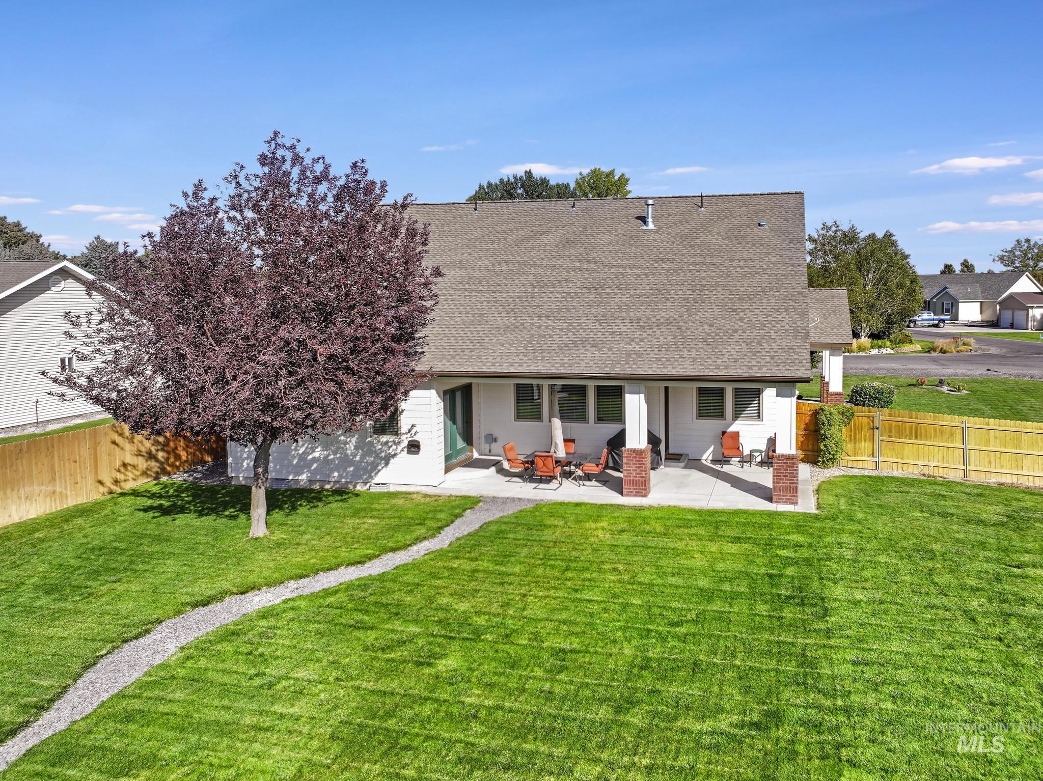 Back of house featuring a fenced backyard, a patio area, and a shingled roof