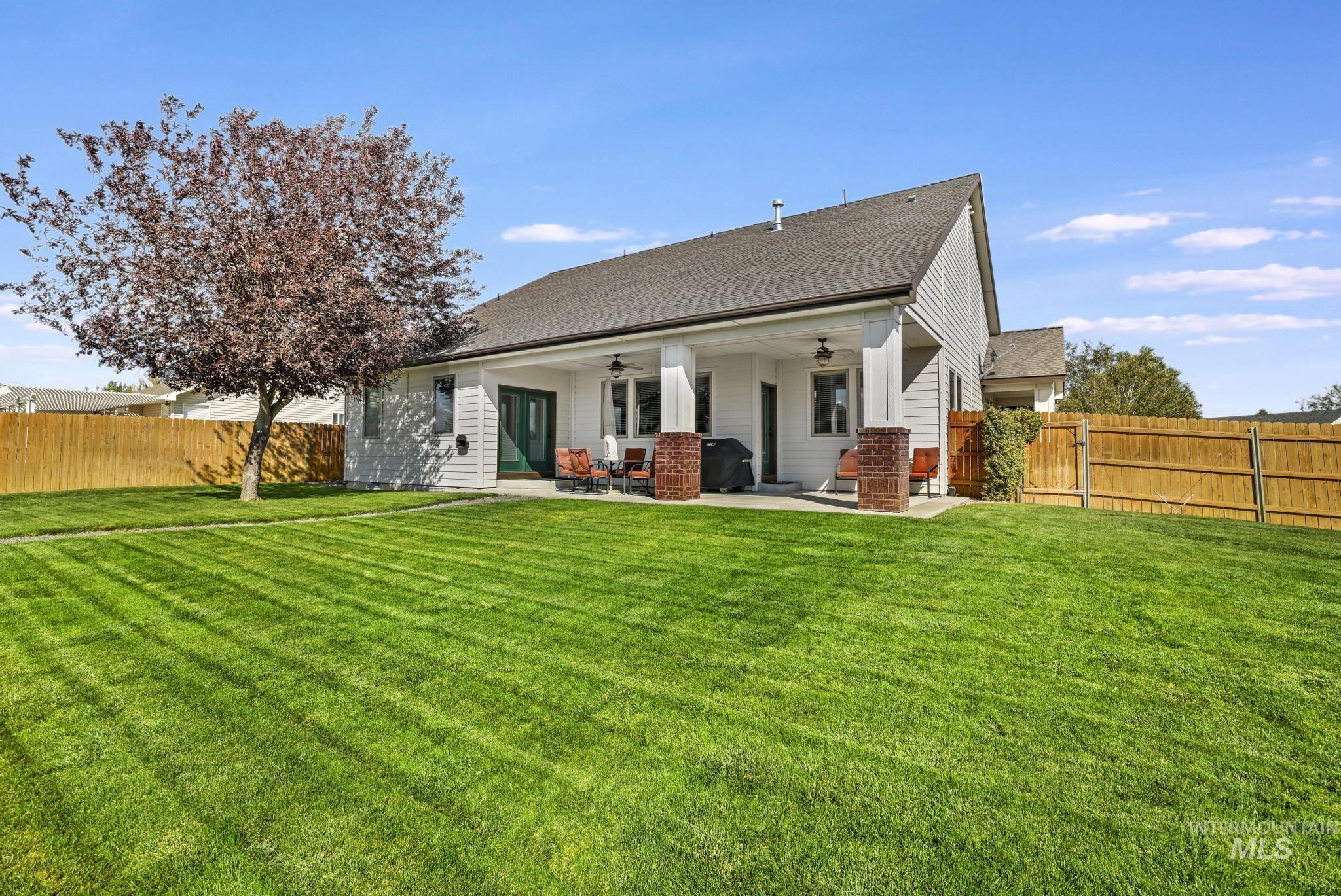 Rear view of property with ceiling fan, a fenced backyard, a patio, and roof with shingles