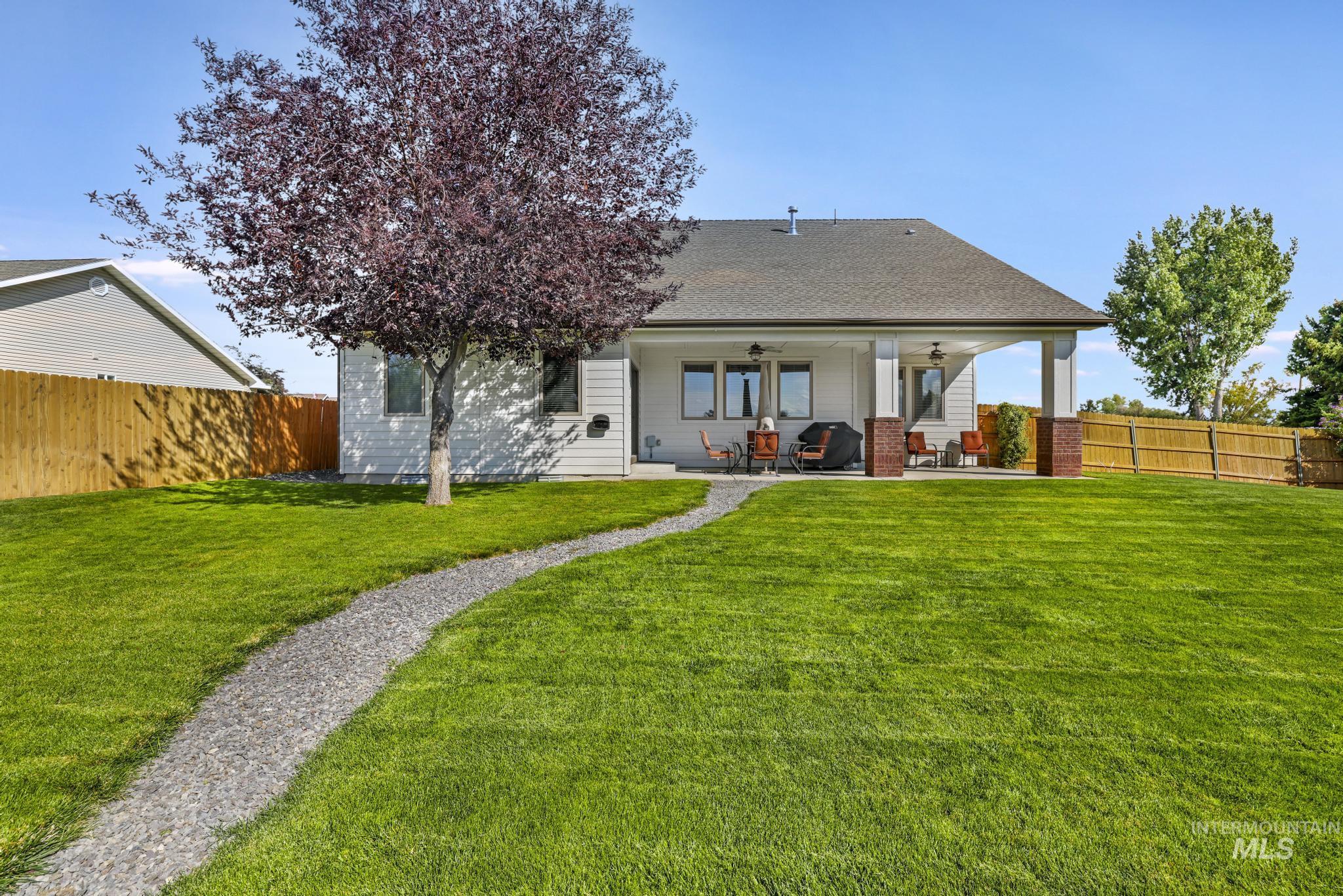 Back of property with ceiling fan, roof with shingles, a patio area, and a fenced backyard