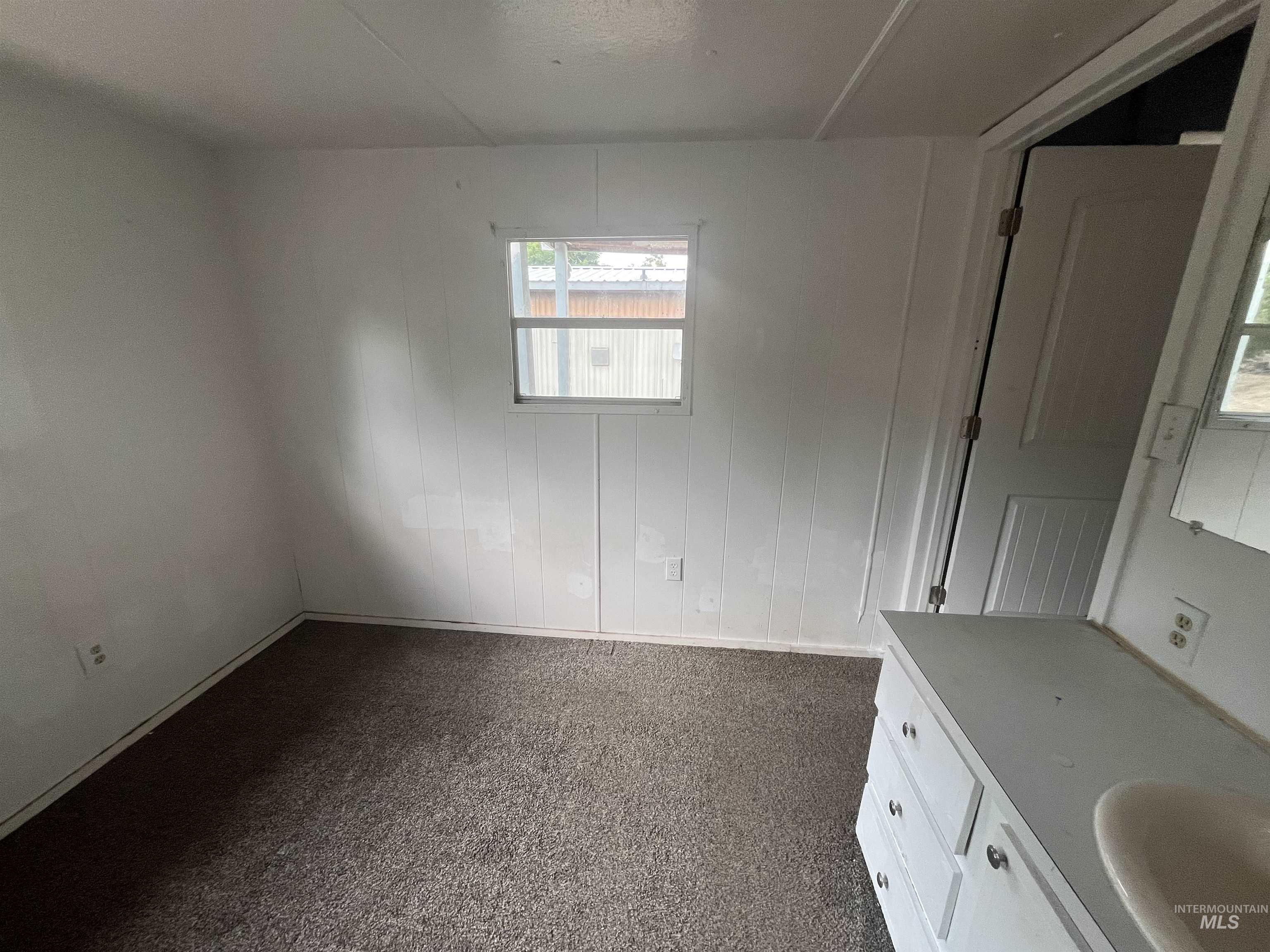 Empty room with dark carpet and a sink