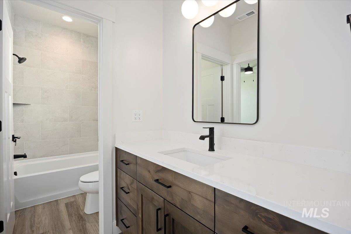 Bathroom with vanity, light wood-type flooring, and shower / bath combination