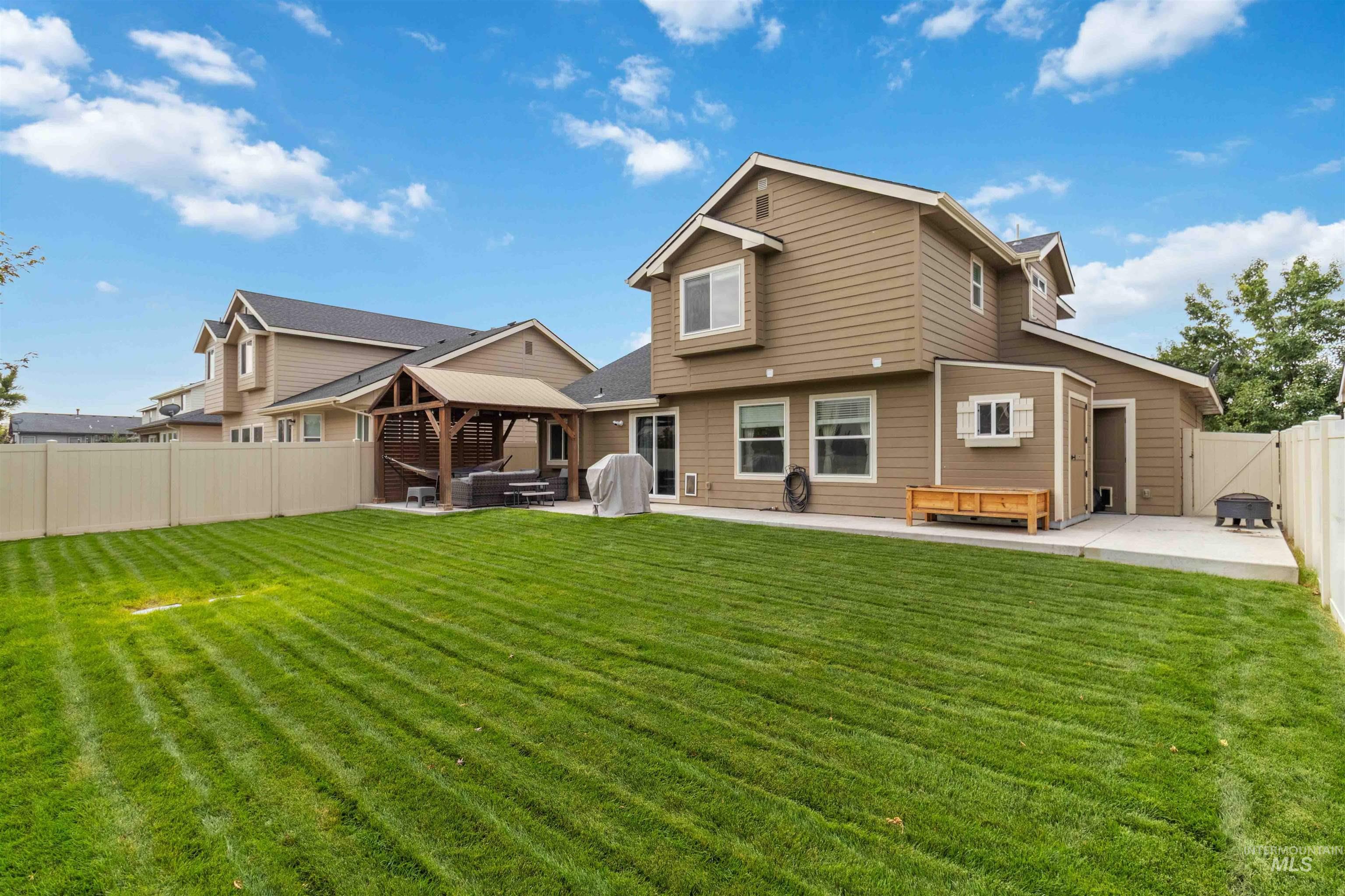 Rear view of house with a patio area, a fenced backyard, and a gazebo