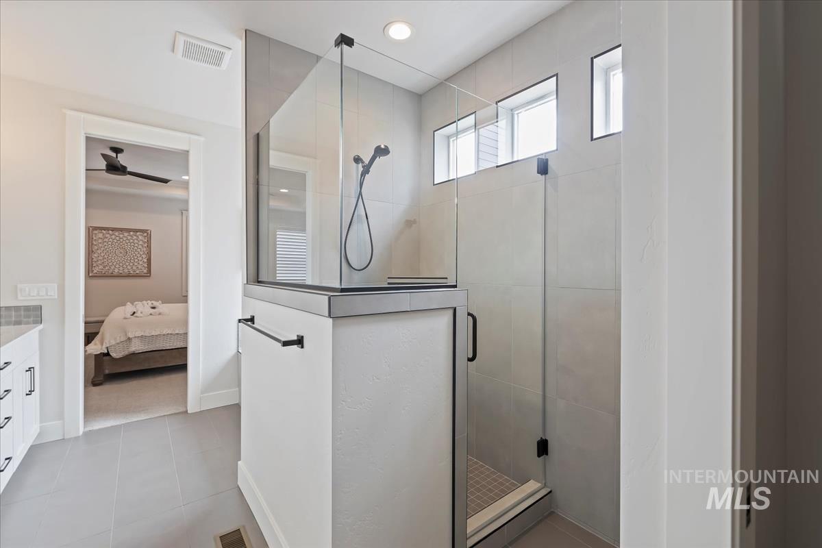 Bathroom with a stall shower, vanity, ensuite bathroom, recessed lighting, and light tile patterned floors