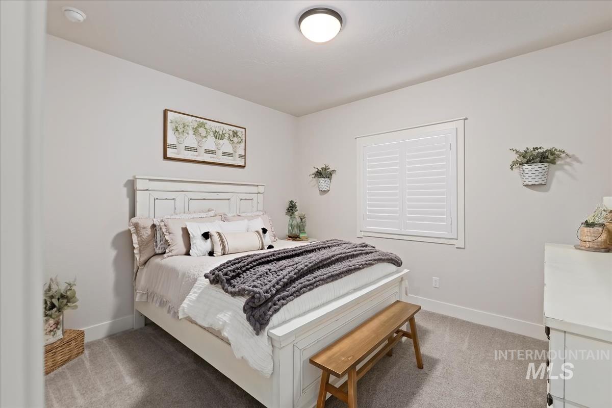 Bedroom featuring baseboards and light colored carpet