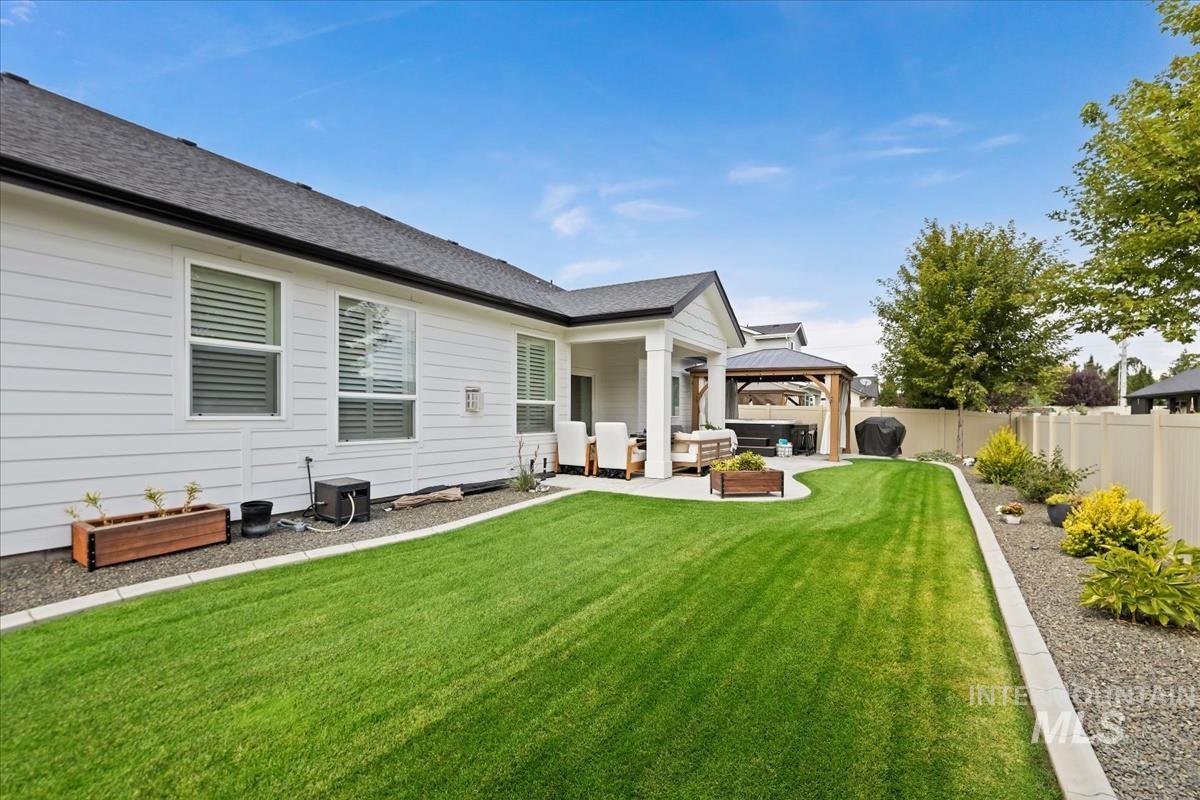 Rear view of house with a gazebo, a patio, an outdoor hangout area, and a shingled roof