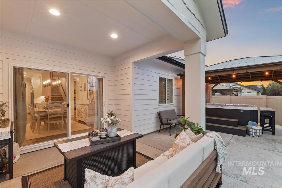 View of patio with a hot tub, a gazebo, and an outdoor hangout area