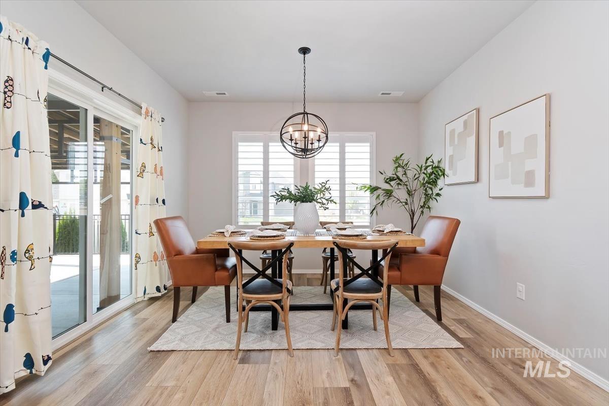Dining area with light wood-style flooring and a chandelier