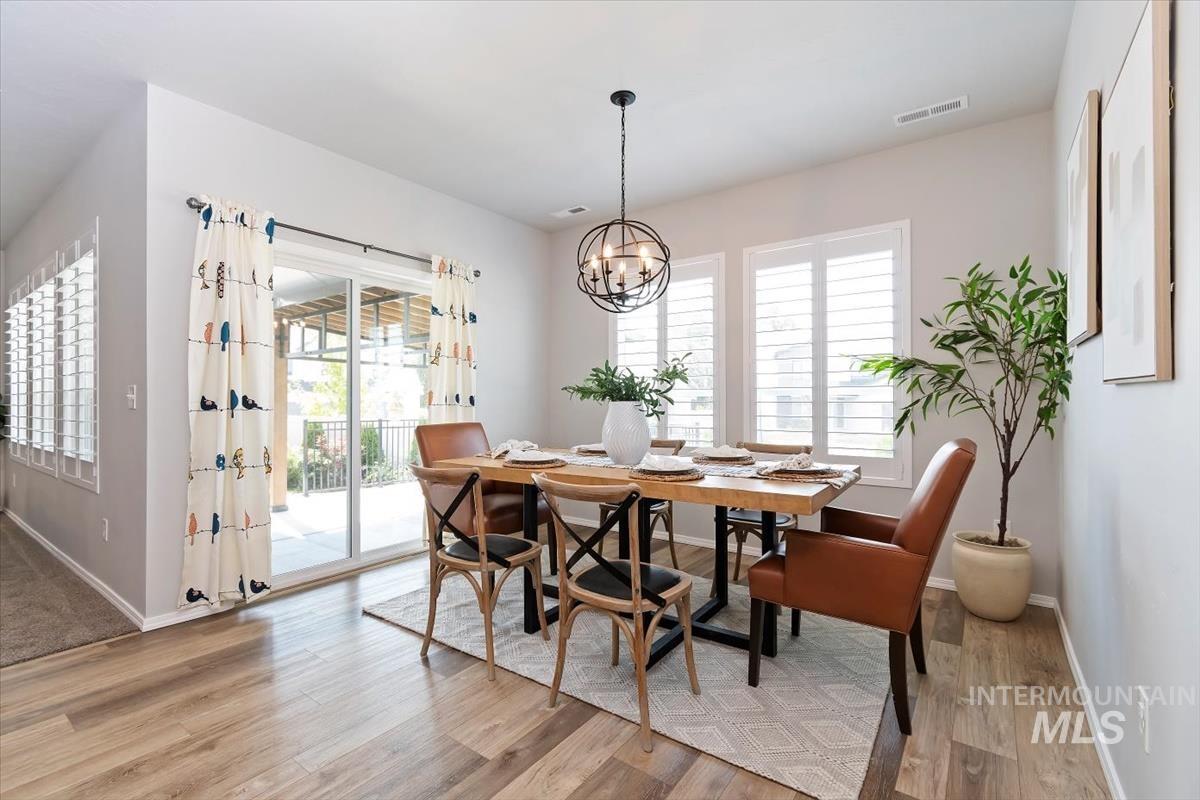 Dining area with light wood-style flooring and a chandelier