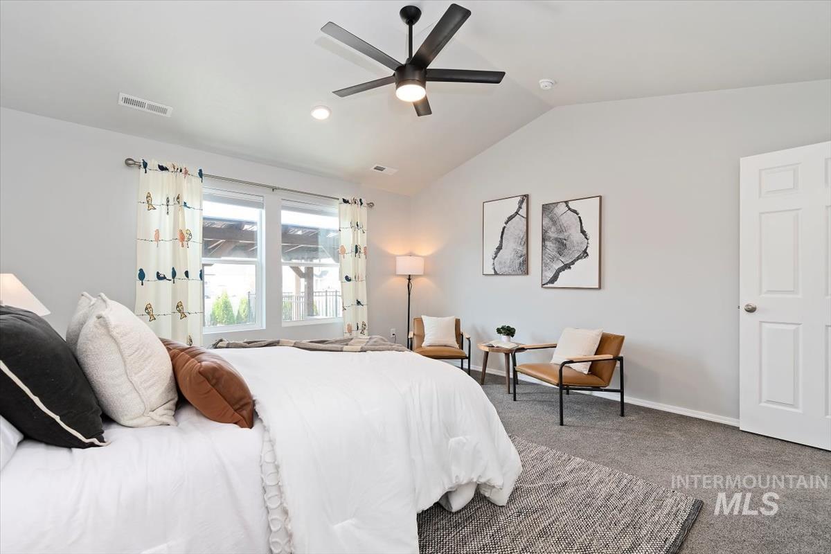 Carpeted bedroom featuring vaulted ceiling, ceiling fan, and recessed lighting