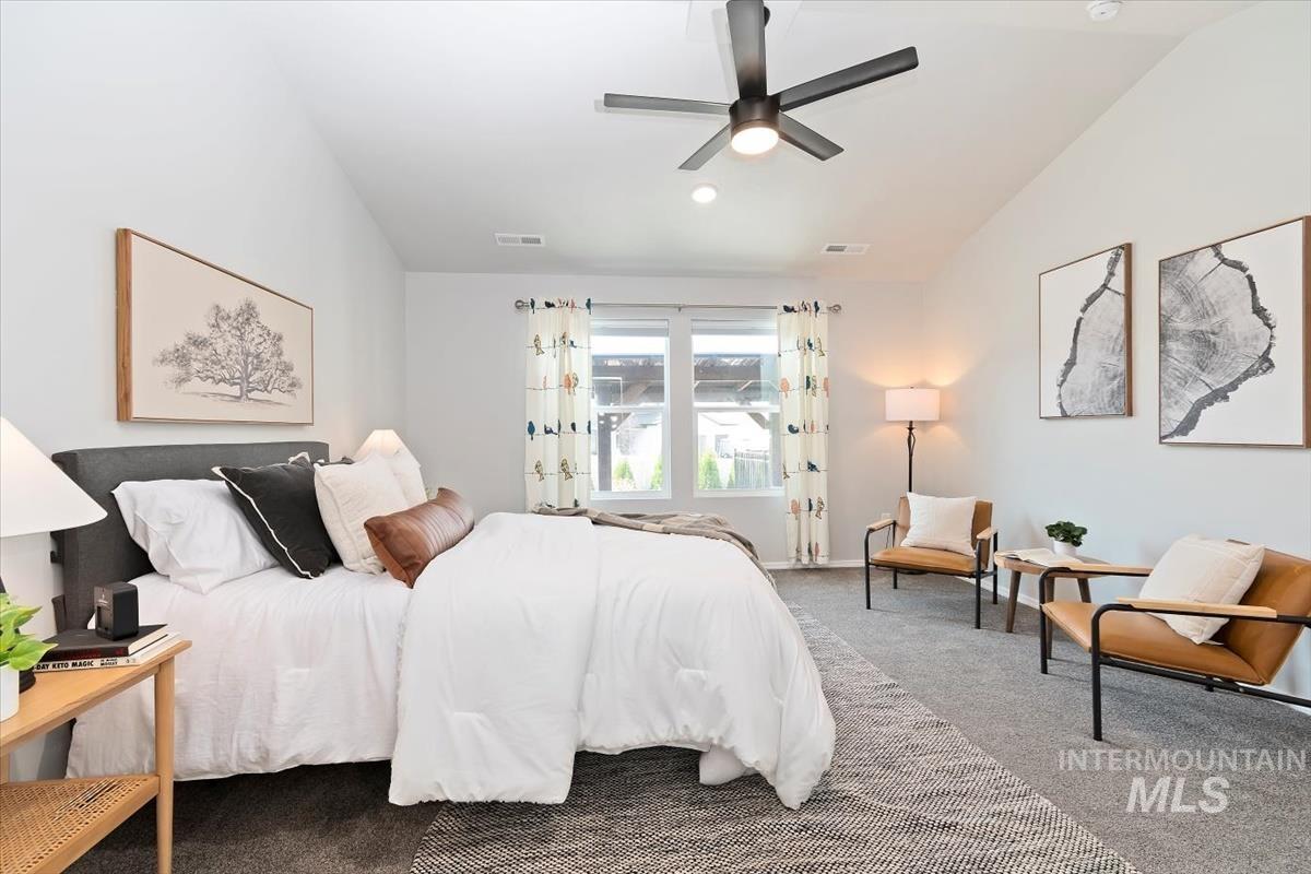Bedroom featuring carpet, lofted ceiling, and a ceiling fan