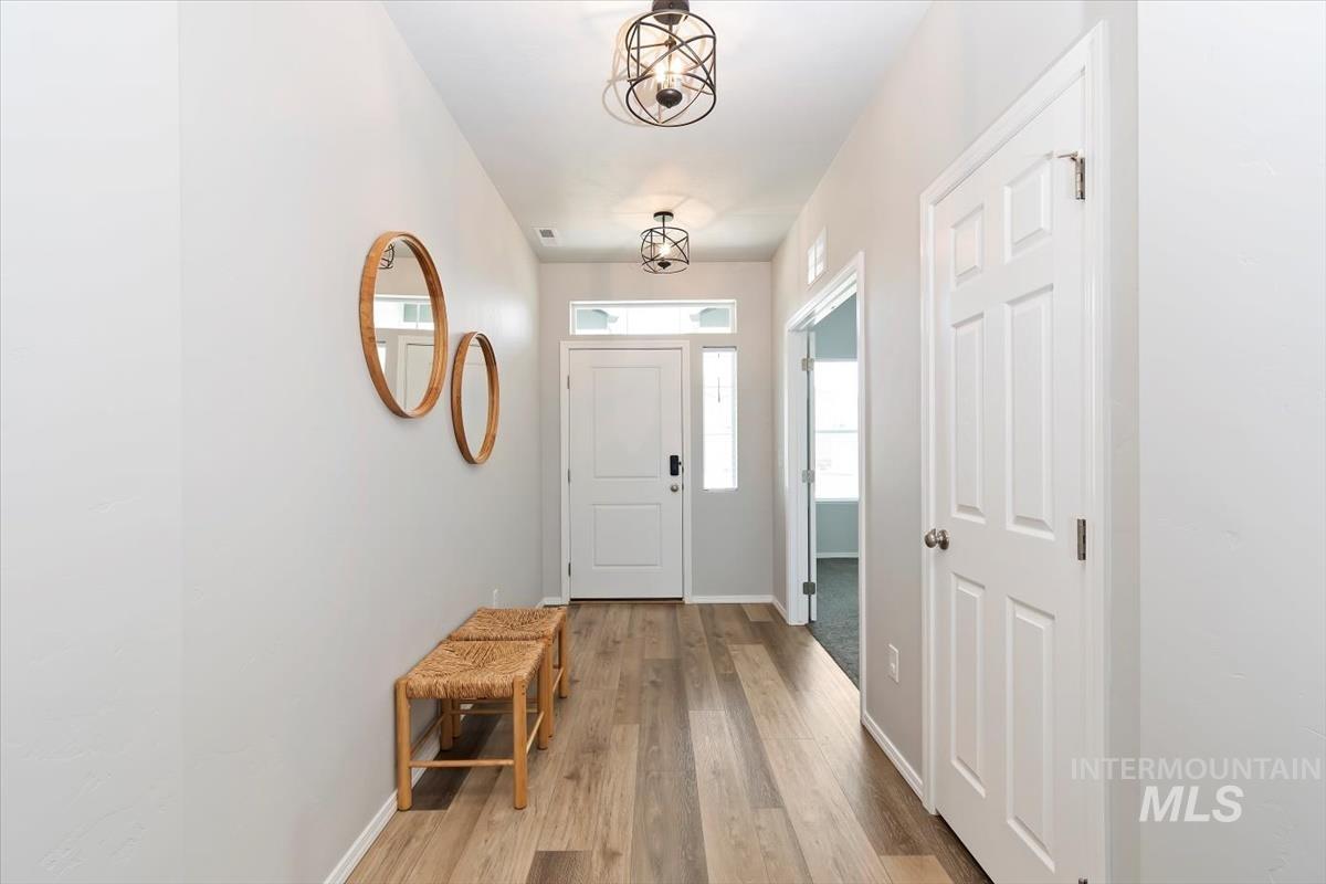 Foyer with light wood finished floors and baseboards