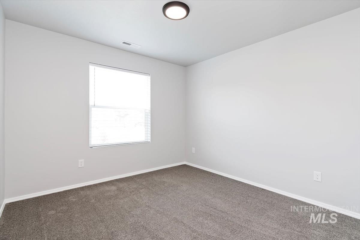 Carpeted empty room featuring baseboards
