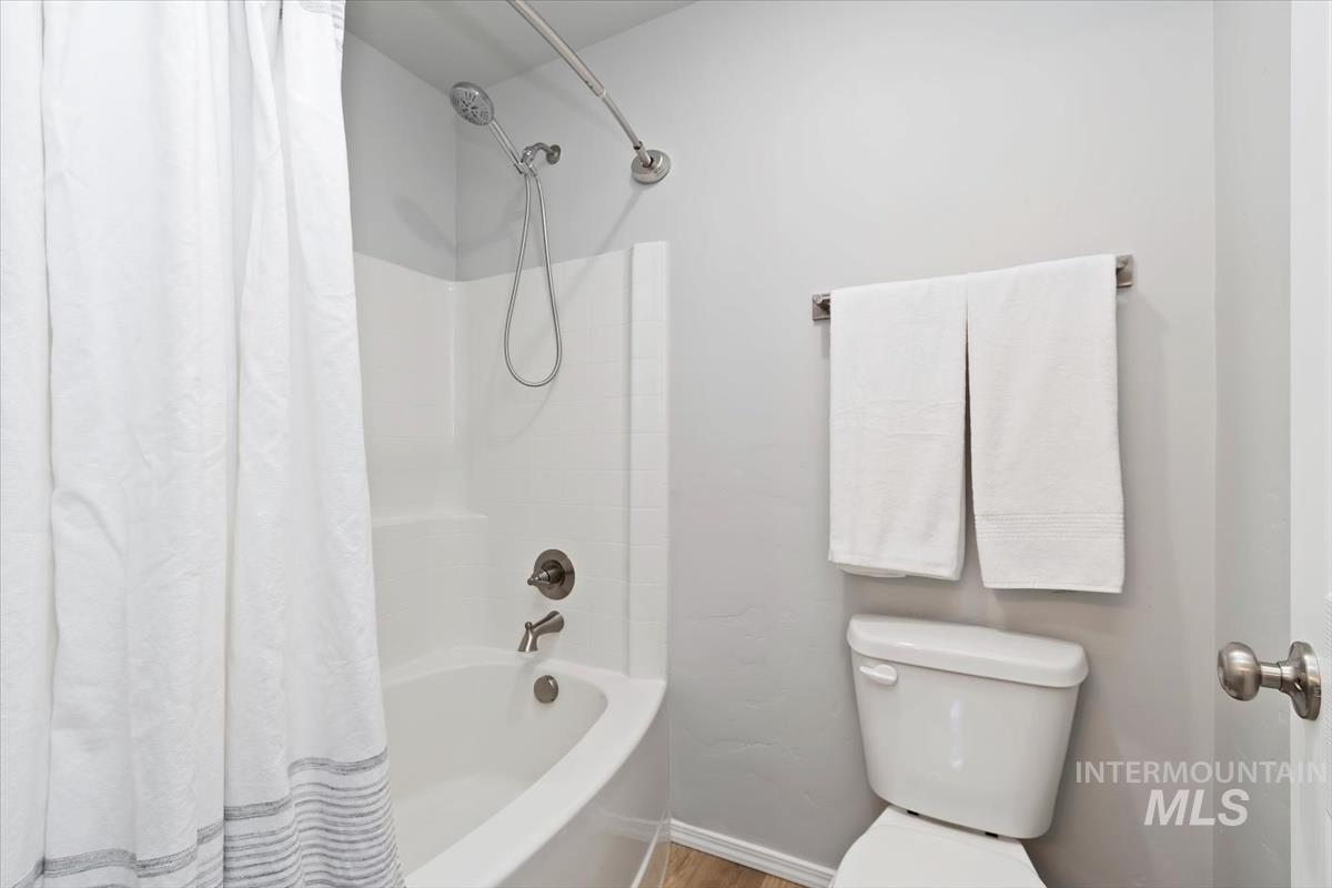 Bathroom featuring shower / bath combo with shower curtain and wood finished floors