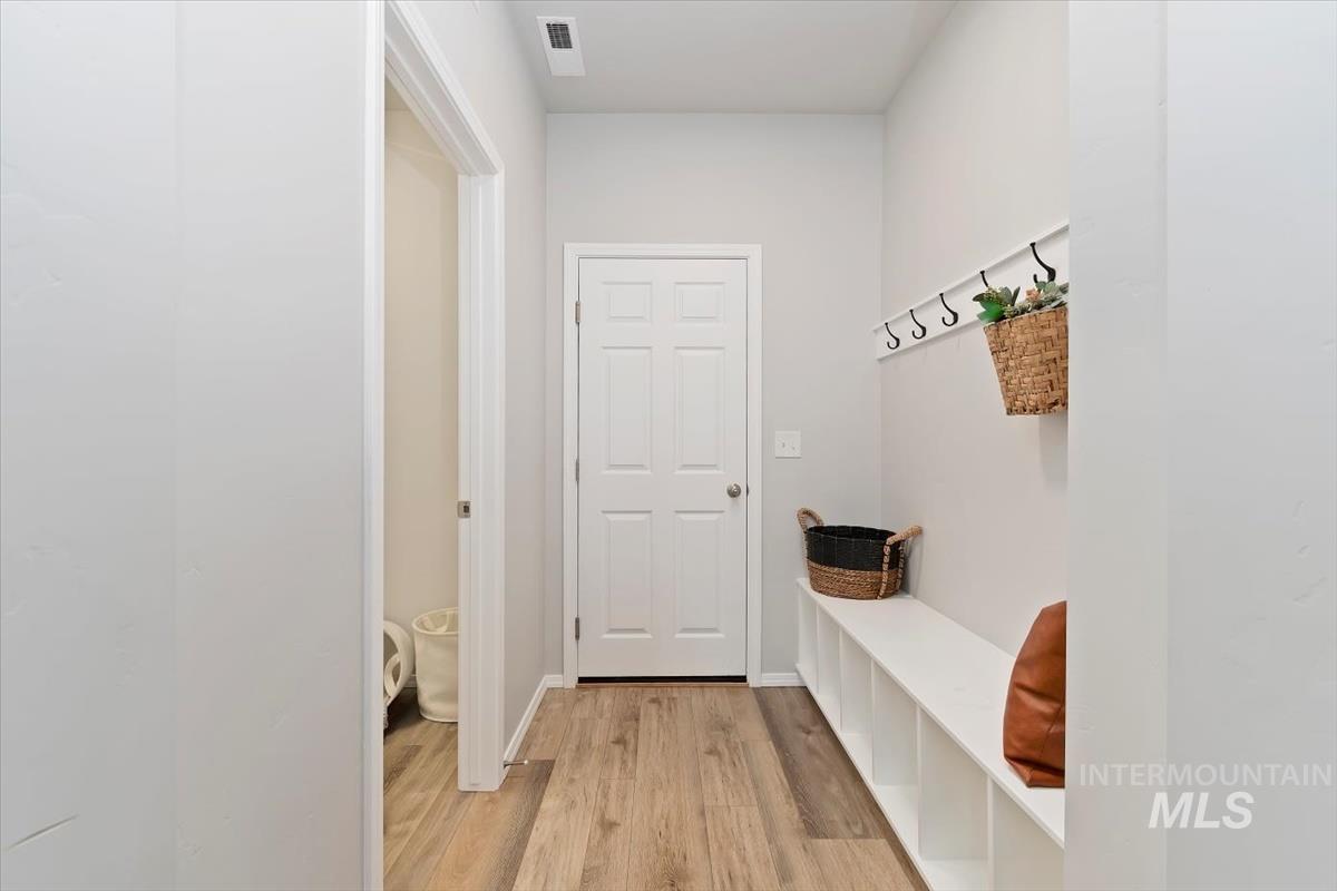 Mudroom featuring light wood finished floors and baseboards