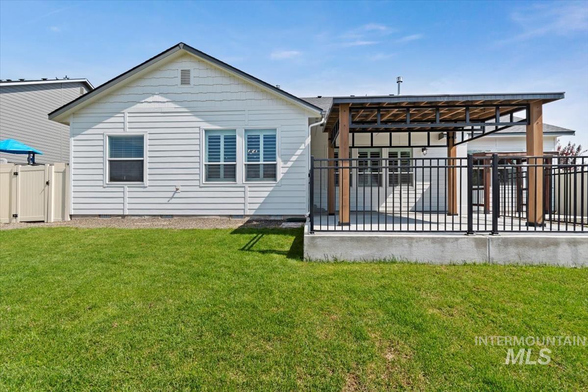 Back of house with a patio, crawl space, and a gate