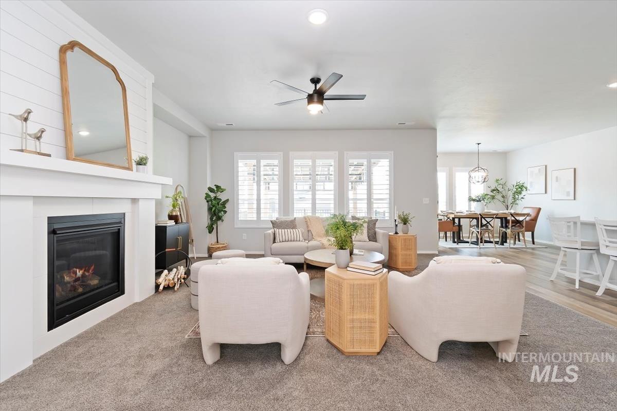 Living room with plenty of natural light, a ceiling fan, a glass covered fireplace, and recessed lighting