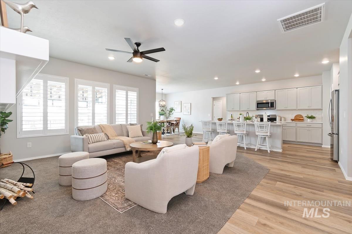 Living room with recessed lighting, a ceiling fan, and light wood-type flooring