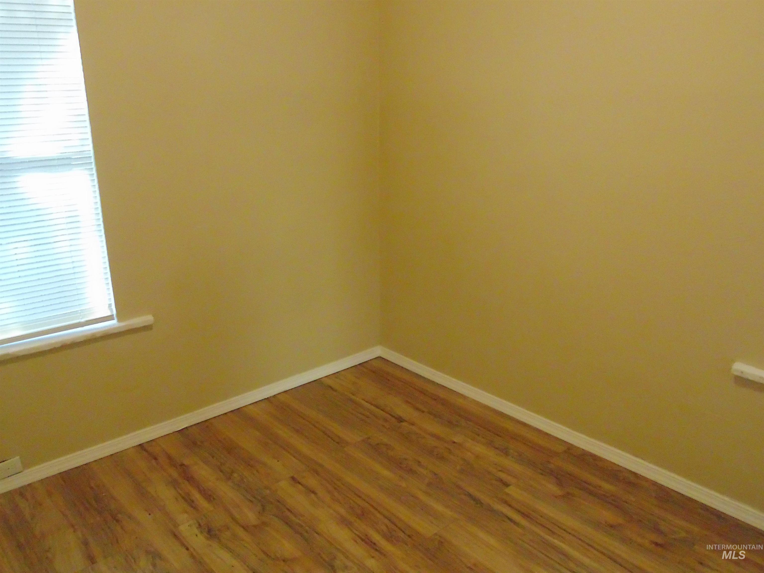 Empty room featuring baseboards and wood finished floors