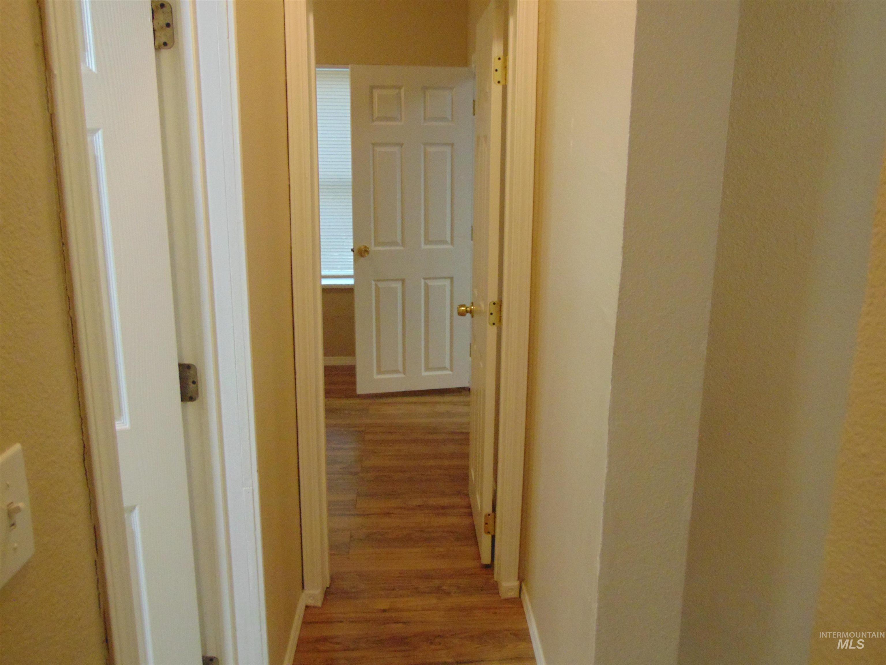 Hallway featuring light wood-type flooring and baseboards