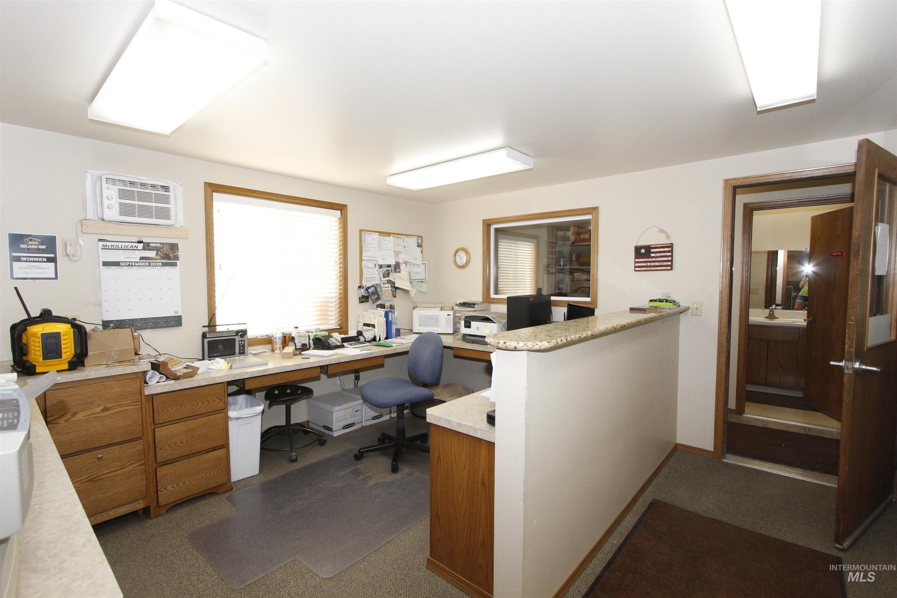 Office space with a wall mounted AC and baseboards