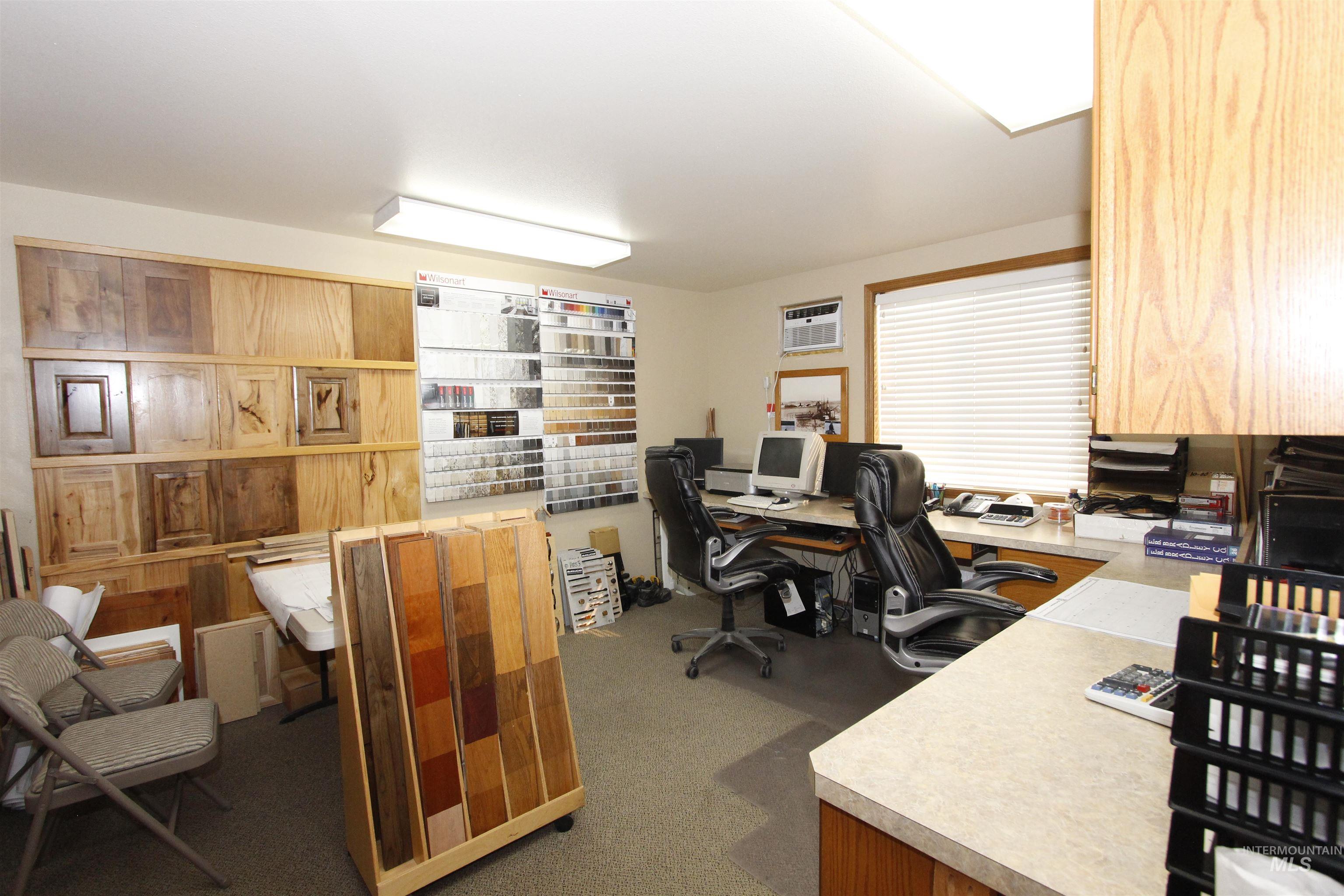 Office space with dark colored carpet and a wall mounted air conditioner