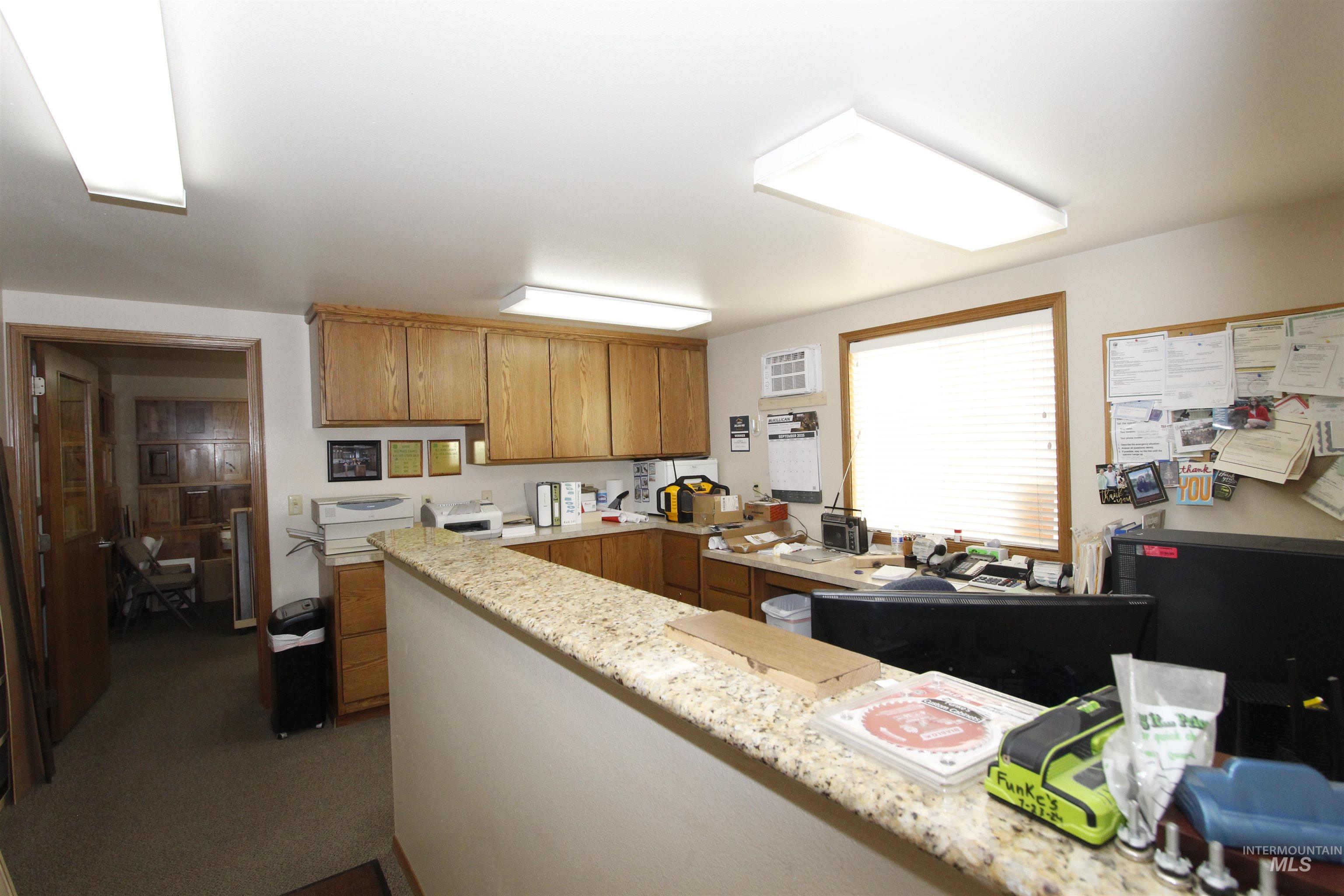 Kitchen with brown cabinetry and dark carpet